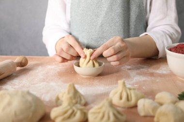 Mutfaktaki masada khinkali yapan kadın, yakın plan.