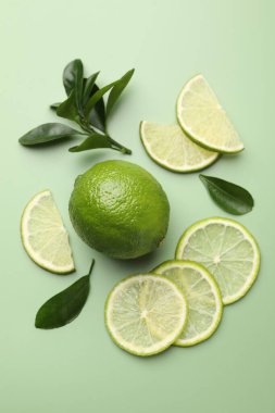 Taze limon ve yapraklar soluk yeşil arka planda, düz yatıyordu.