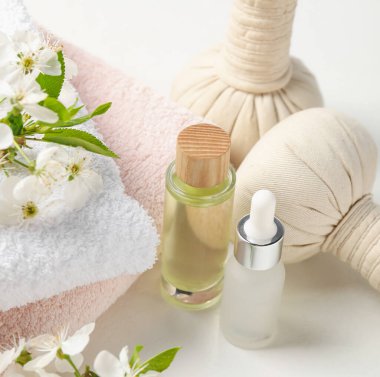 Beyaz masa üzerinde güzel çiçekli kaplıca ürünleri ve dallar, yakın çekim