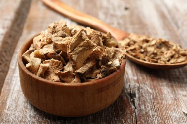 Kuru hindiba kökleri kasede ve kaşık tahta masada, yakın plan.