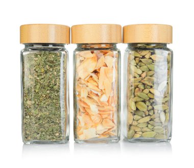 Beyaz kavanozlardaki farklı aromatik baharatlar.