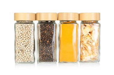 Beyaz kavanozlardaki farklı aromatik baharatlar.