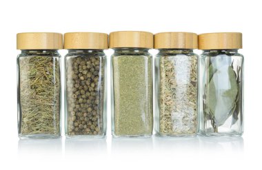 Beyaz kavanozlardaki farklı aromatik baharatlar.