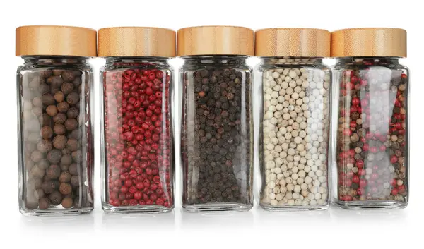 Beyaz kavanozlardaki farklı aromatik baharatlar.