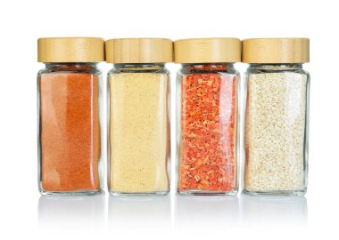 Beyaz kavanozlardaki farklı aromatik baharatlar.