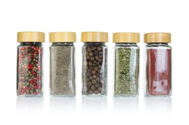 Beyaz kavanozlardaki farklı aromatik baharatlar.