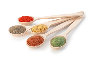 Beyaz kaşıklardaki farklı aromatik baharatlar.