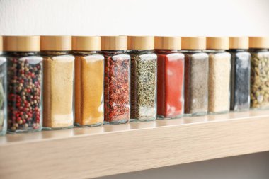 Kapalı alandaki ahşap raflarda farklı aromatik baharatlar.