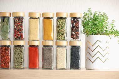 Kapalı alandaki ahşap raftaki kavanozlardaki farklı aromatik baharatlar.
