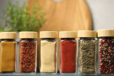 Ayna yüzeyindeki kavanozlarda farklı aromatik baharatlar, yakın plan.