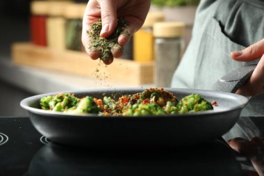 Mutfağa baharat ekleyen kadın, yakın plan.