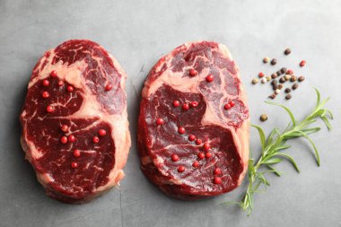 Çiğ et parçaları ve baharatlar gri dokulu masa üzerinde, düz yatıyordu.