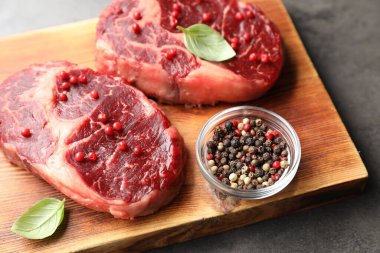 Gri masada çiğ et ve baharat parçaları, yakın plan.