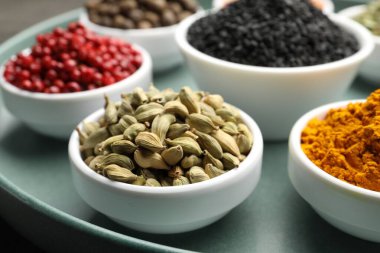 Gri masada farklı aromatik baharatlar, yakın plan.