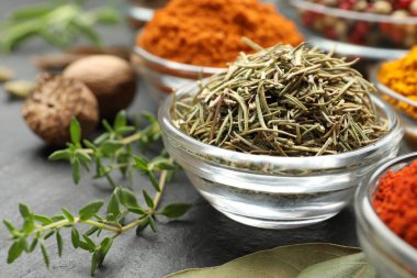 Gri masada farklı aromatik baharatlar, yakın plan.