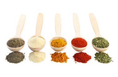 Beyaz kaşıklardaki farklı aromatik baharatlar.