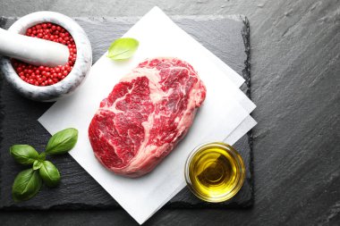 Siyah masada çiğ et ve baharat var.