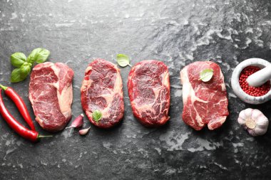 Koyu masada çiğ et ve baharat parçaları, düz yatıyordu.