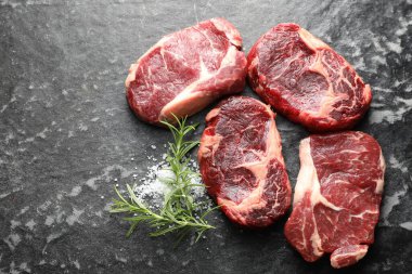 Koyu masa üzerinde çiğ et ve baharat parçaları, düz. Metin için boşluk