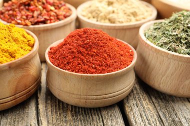 Tahta masadaki kaselerde farklı aromatik baharatlar, yakın plan.