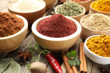 Ahşap masada farklı aromatik baharatlar, yakın plan.