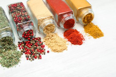 Beyaz masadaki kavanozlarda farklı aromatik baharatlar