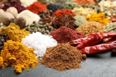 Gri masada farklı aromatik baharatlar, yakın plan.