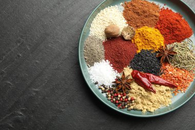 Koyu dokulu masa üzerinde farklı aromatik baharatlar, üst manzara. Metin için boşluk