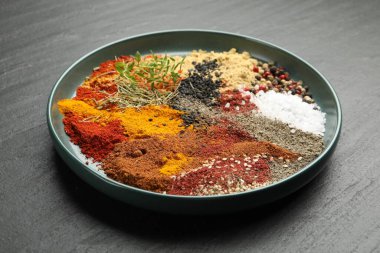 Koyu dokulu masada farklı aromatik baharatlar, yakın plan.