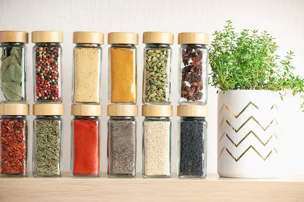 Kapalı alandaki ahşap raftaki kavanozlardaki farklı aromatik baharatlar.