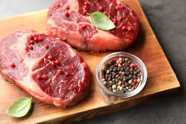Gri masada çiğ et ve baharat parçaları, yakın plan.