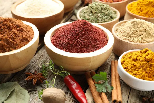 Ahşap masada farklı aromatik baharatlar, yakın plan.