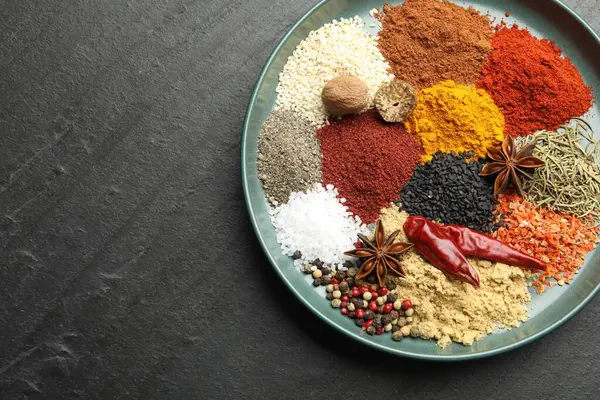 Koyu dokulu masa üzerinde farklı aromatik baharatlar, üst manzara. Metin için boşluk