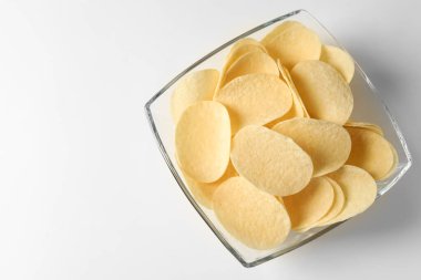 Beyaz arka planda leziz patates cipsleri, üst manzara. Metin için boşluk