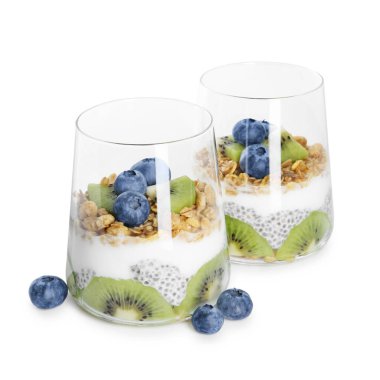 Chia tohumlu lezzetli tatlı, yoğurt, granola, yabanmersini ve kivi beyaz üzerine izole edilmiş bardaklarda. Süper yemek.