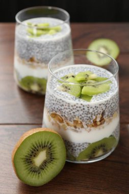 Chia tohumlu lezzetli tatlı, yoğurt, tahıl gevreği ve ahşap masada kivi, yakın plan. Süper yemek.