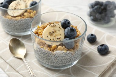 Chia tohumlu lezzetli tatlı, yoğurt, granola, yaban mersini ve muz, yakın plan. Süper yemek.