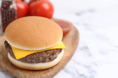 Beyaz mermer masada leziz bir çizburger, yakın plan. Metin için boşluk