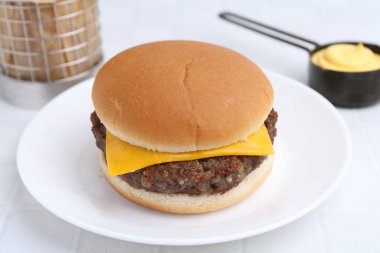 Lezzetli köfteli çizburger ve soslu beyaz masa, yakın plan.