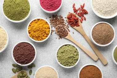 Açık gri masada farklı süper yiyecek tozları, düz yatıyordu.