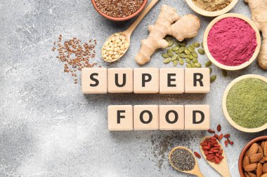 Farklı süper yiyecekler ve gri desenli masada duran küplerden yapılmış kelimeler. Metin için boşluk