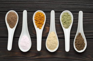 Tahta masadaki kaşıklarda farklı süper yiyecek tozları.
