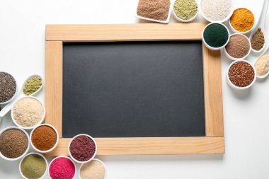 Farklı süper gıda ürünleri ve beyaz arka planda boş karatahta, düz yatak. Metin için boşluk