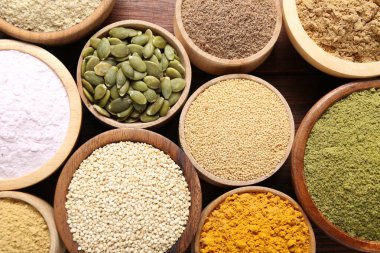 Tabaklardaki farklı süper yiyecekler masada, düz yerde.