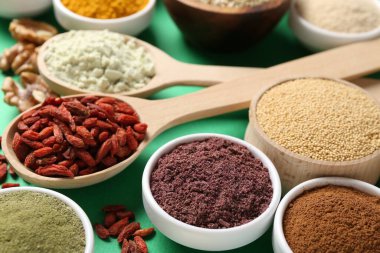 Yeşil arka planda farklı süper gıda ürünleri, yakın plan