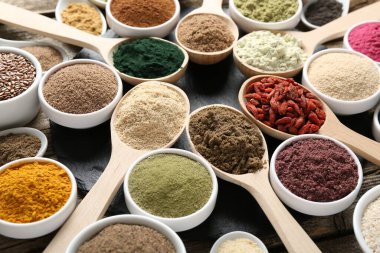 Kaşık ve kaselerdeki farklı süper yiyecekler masada, yakın plan.