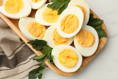 Beyaz mermer masada haşlanmış yumurta ve maydanoz.