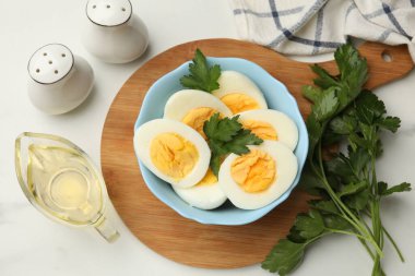 Haşlanmış yumurta, maydanoz ve yağ beyaz mermer masada, düz yatıyordu.