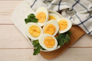 Ahşap masada kaynamış yumurta ve maydanoz.