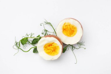 Haşlanmış yumurta ve beyaz arka planda mikro yeşillikler.